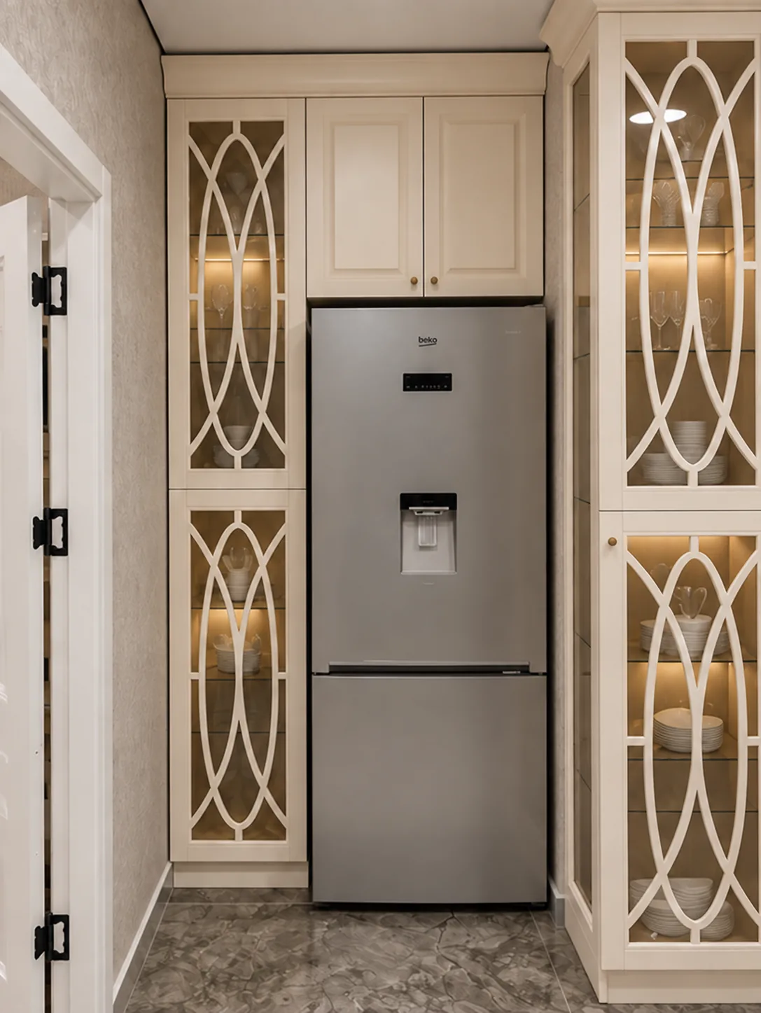 Cream kitchen with glazed oval-fretwork cabinetry, oak worktop and marble splashback — larder and integrated fridge
