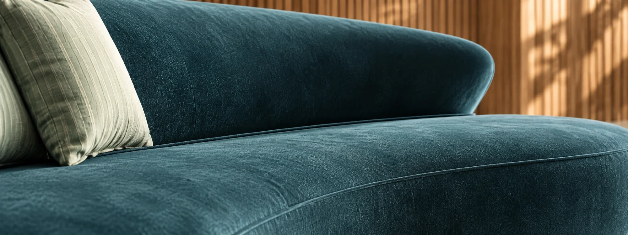 Close view of the sofa’s rounded arm and velvet