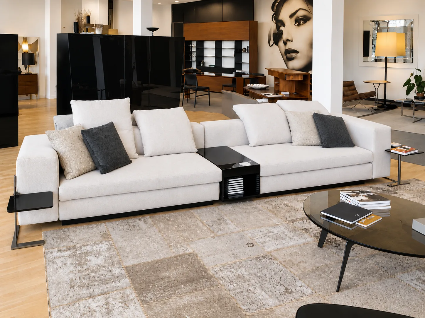 A long white modular sofa with dark cushions in a gallery-like living space