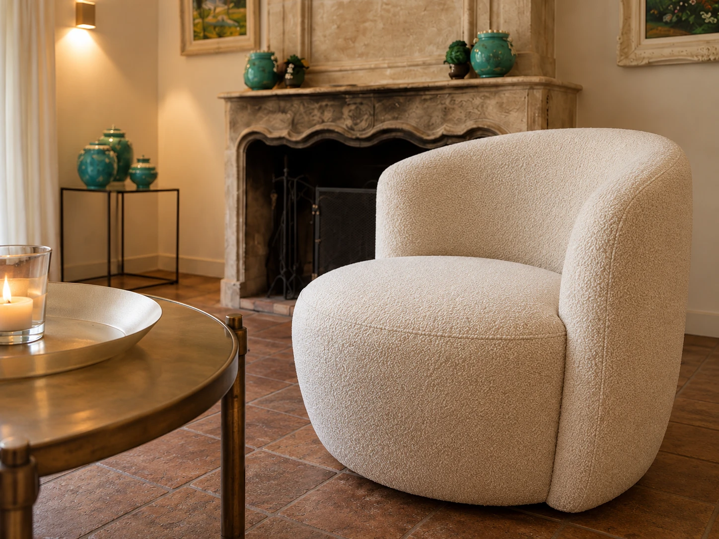 Detail of a rounded armchair in textured cream bouclé before the fireplace