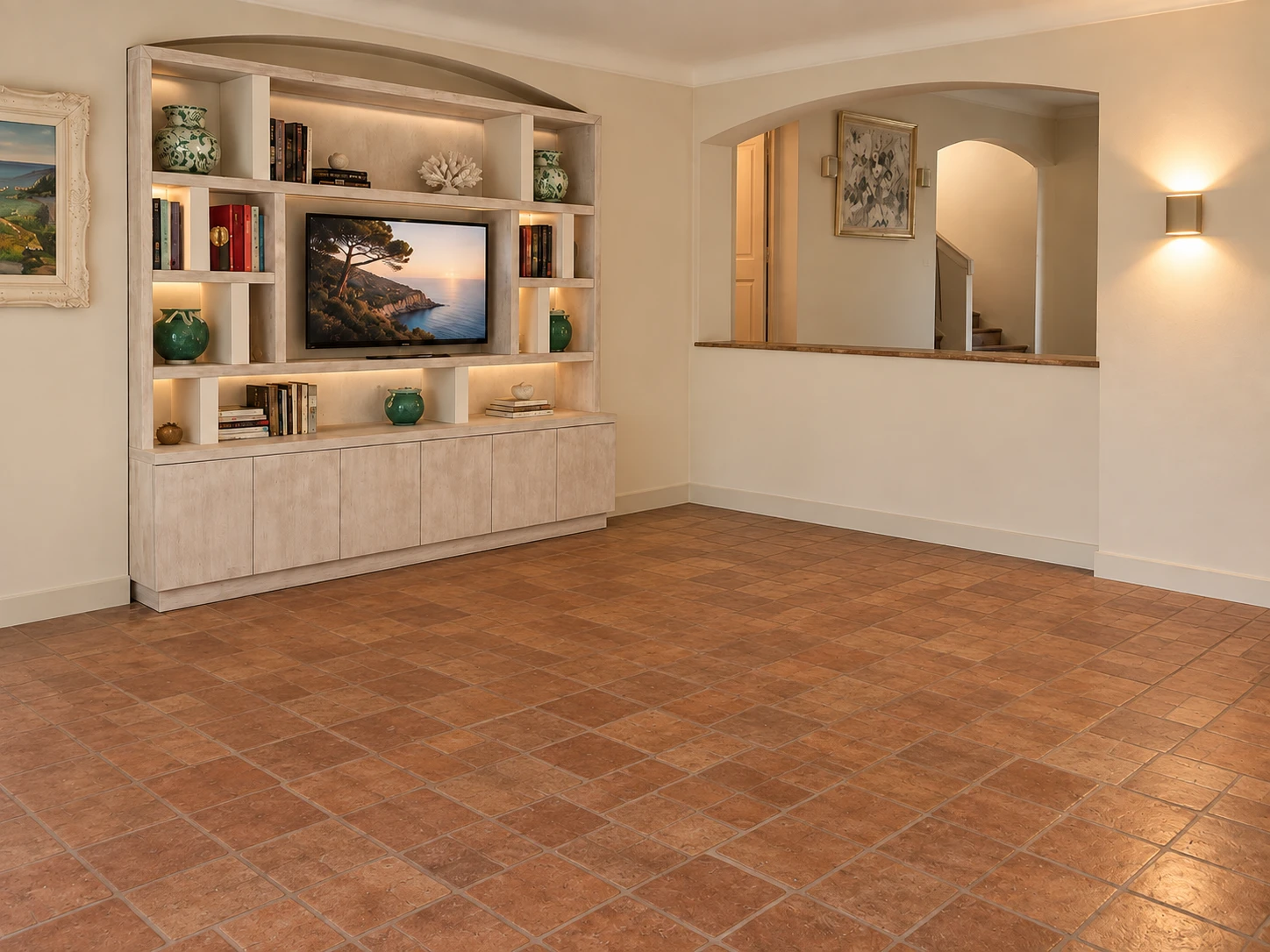 The shelving side of the room before it was furnished: an empty tiled floor in front of the lit shelving wall