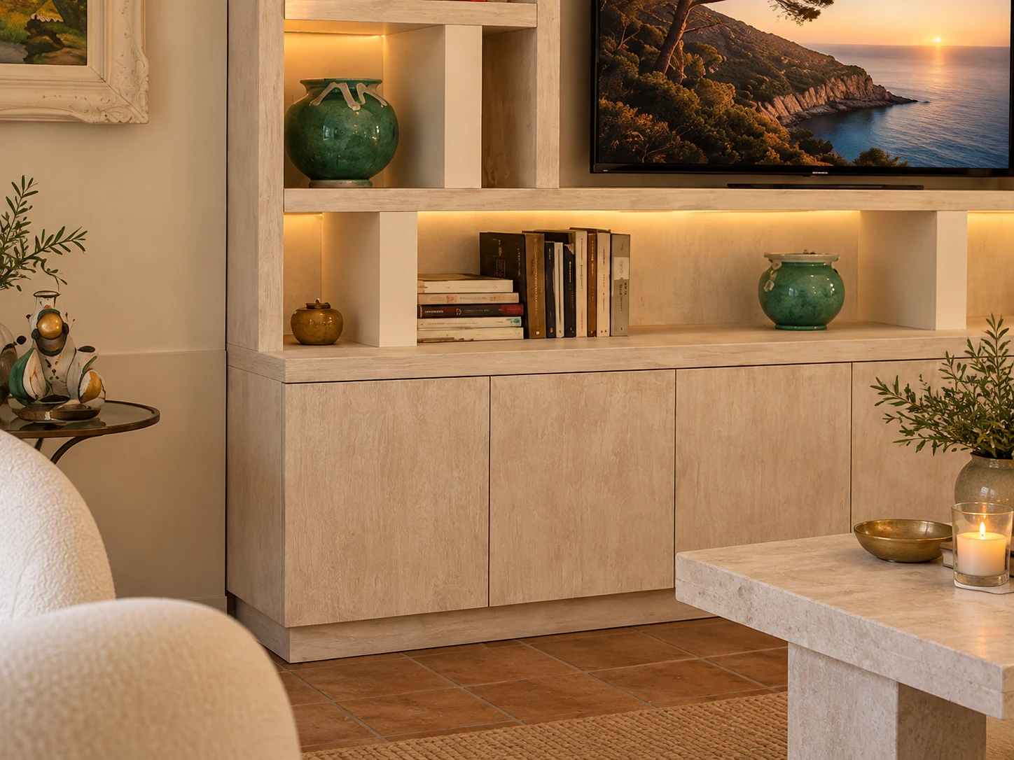 Detail of the lit shelving wall, with a travertine coffee table in the foreground