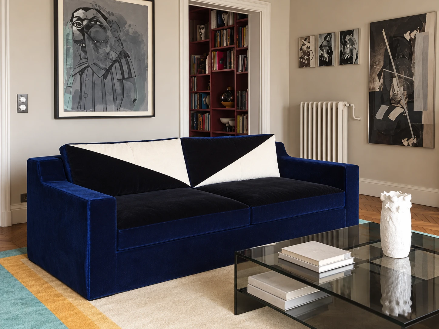 A blue velvet sofa with two back cushions pieced in navy and ivory