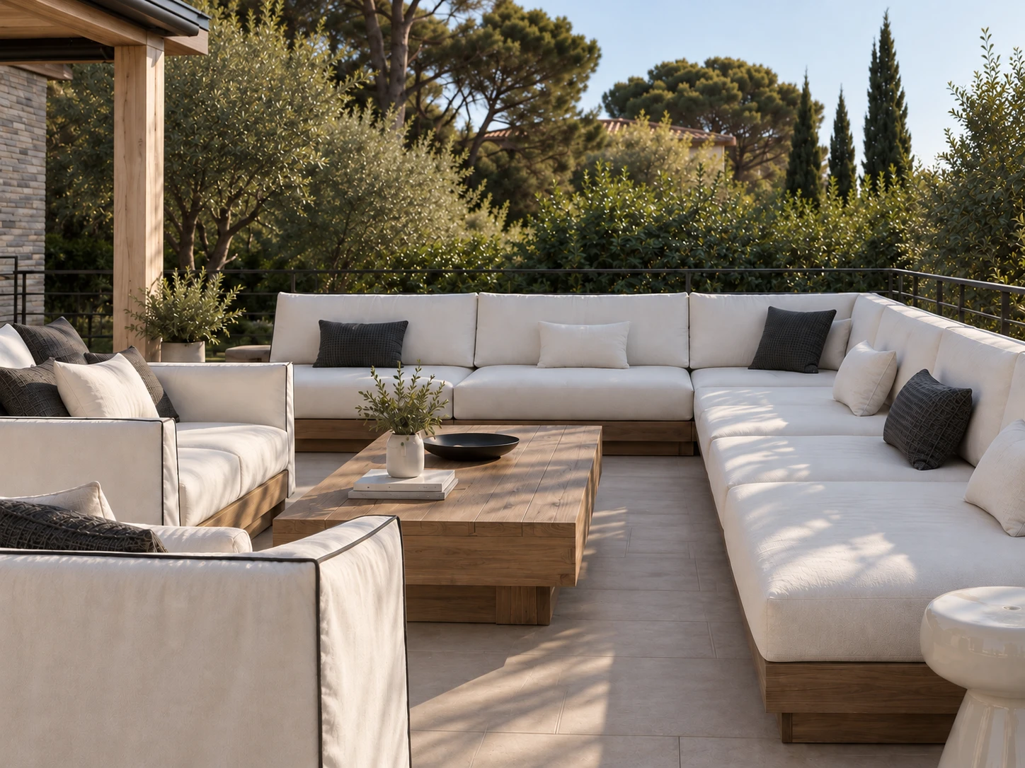 The lounge from the corner: the long white sofa wrapping the terrace, with dark and white cushions