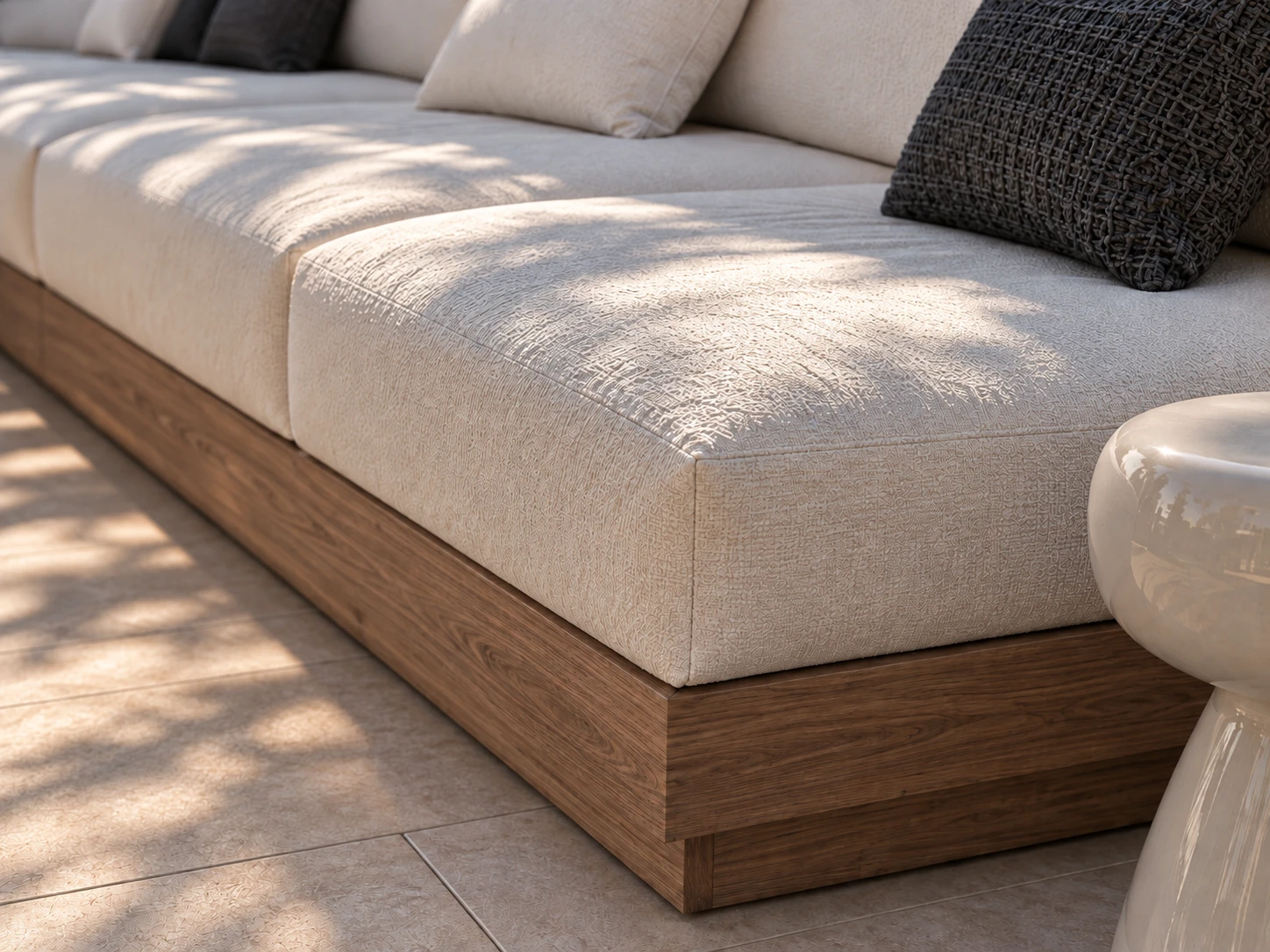 Detail of the built-in sofa: textured white seat cushions on a timber plinth